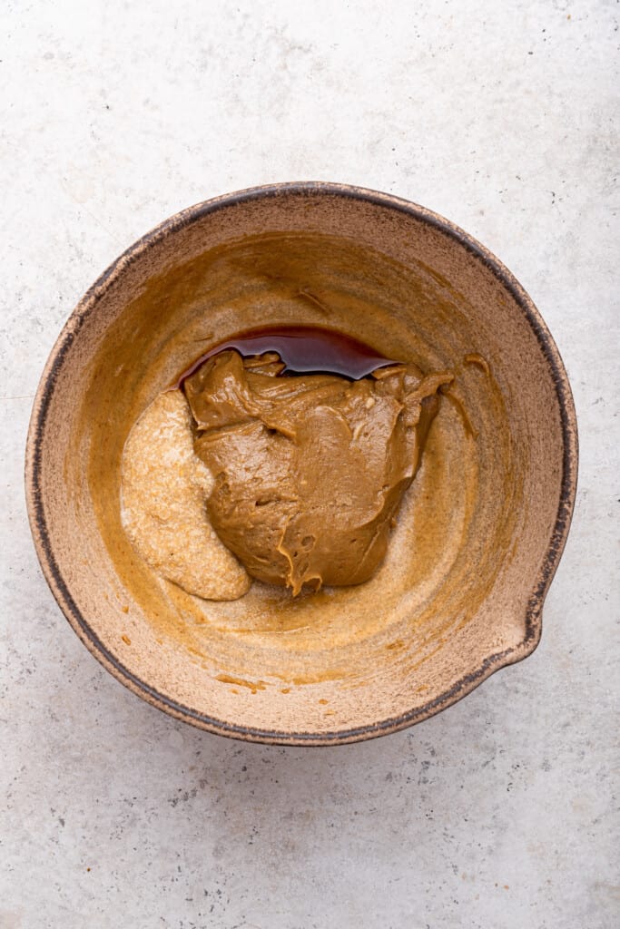 Overhead view of wet ingredients for tahini chocolate chip cookie dough before mixing