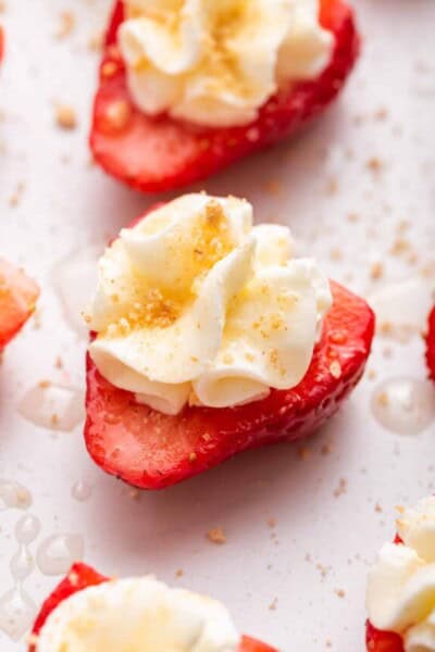 Deviled strawberries topped with whipped cream, graham cracker crumbs, and honey