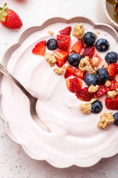 Bowl of whipped cottage cheese garnished with fresh berries and granola