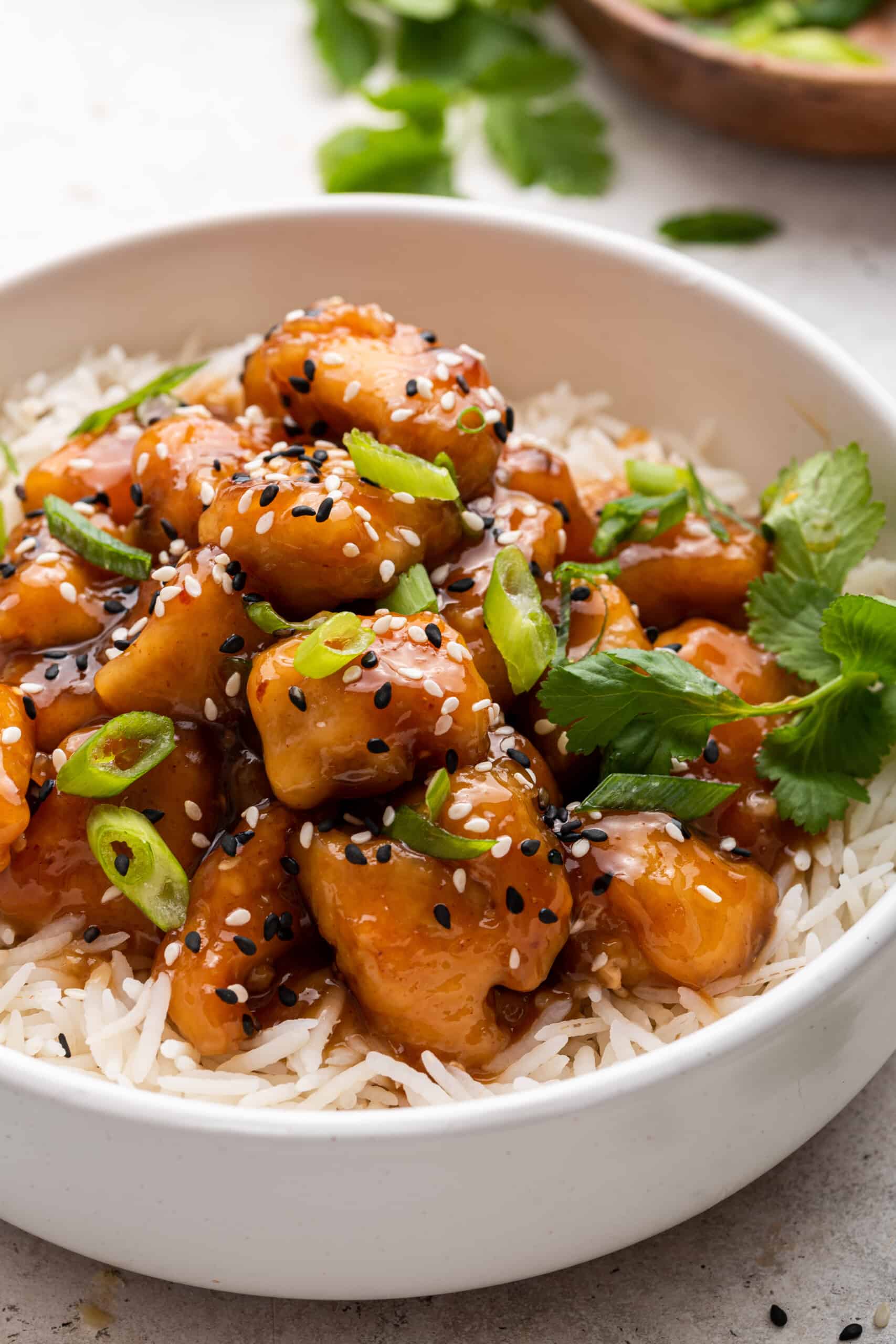 Honey sriracha chicken on bed of rice in bowl