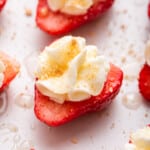 Deviled strawberries topped with whipped cream, graham cracker crumbs, and honey