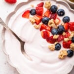 Bowl of whipped cottage cheese garnished with fresh berries and granola