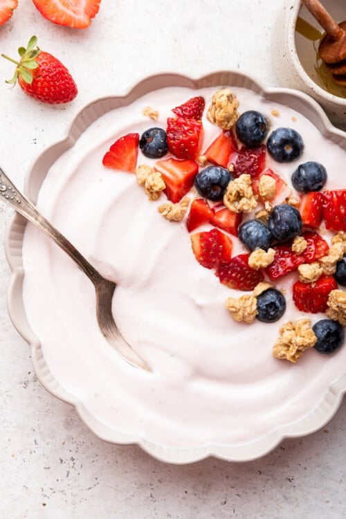 Bowl of whipped cottage cheese garnished with fresh berries and granola