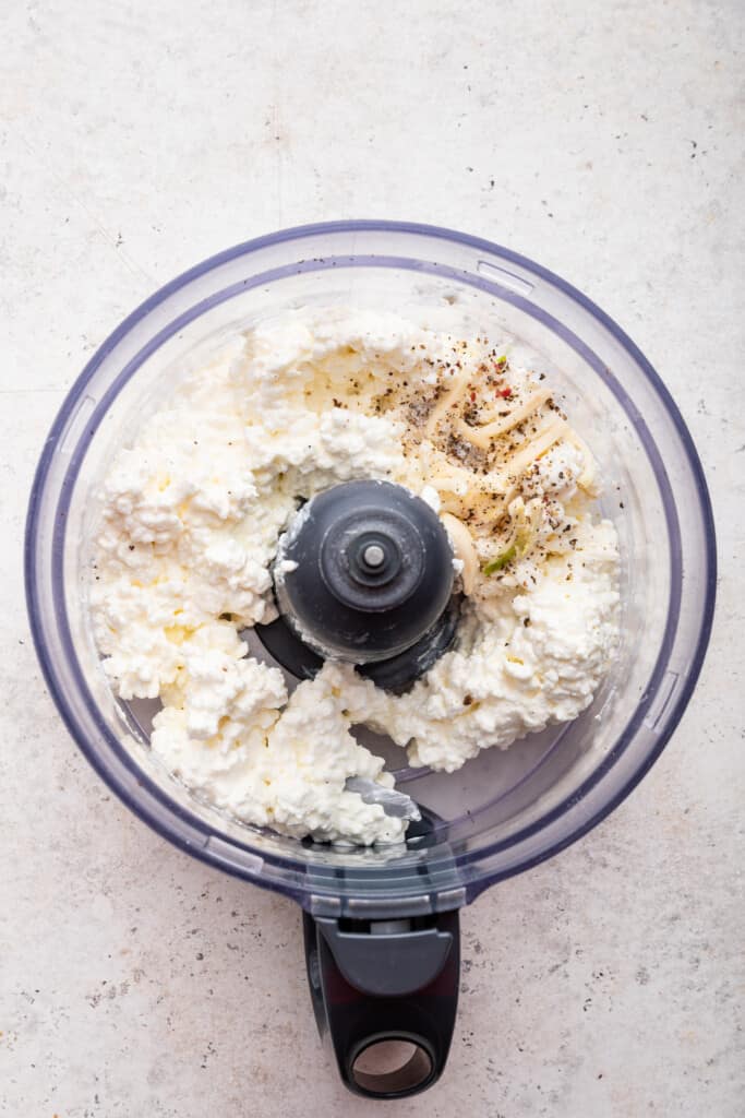 Overhead view of ingredients for whipped cottage cheese in food processor