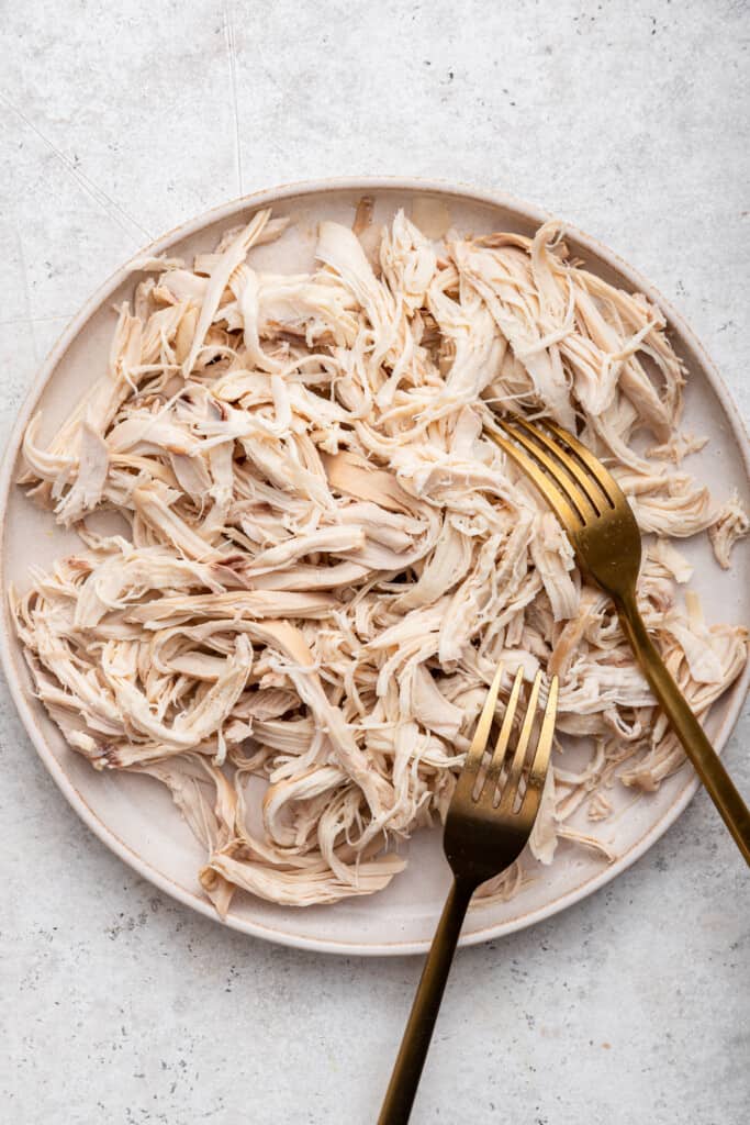 Shredded chicken on plate with 2 forks
