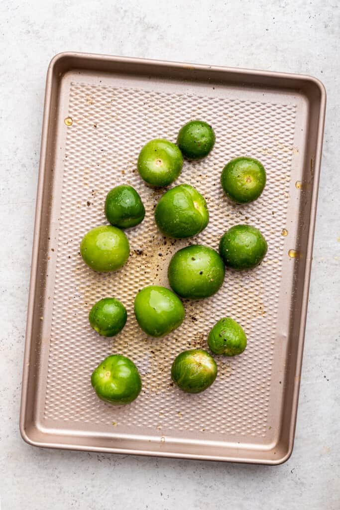 Overhead view of raw tomatillos on baking sheet