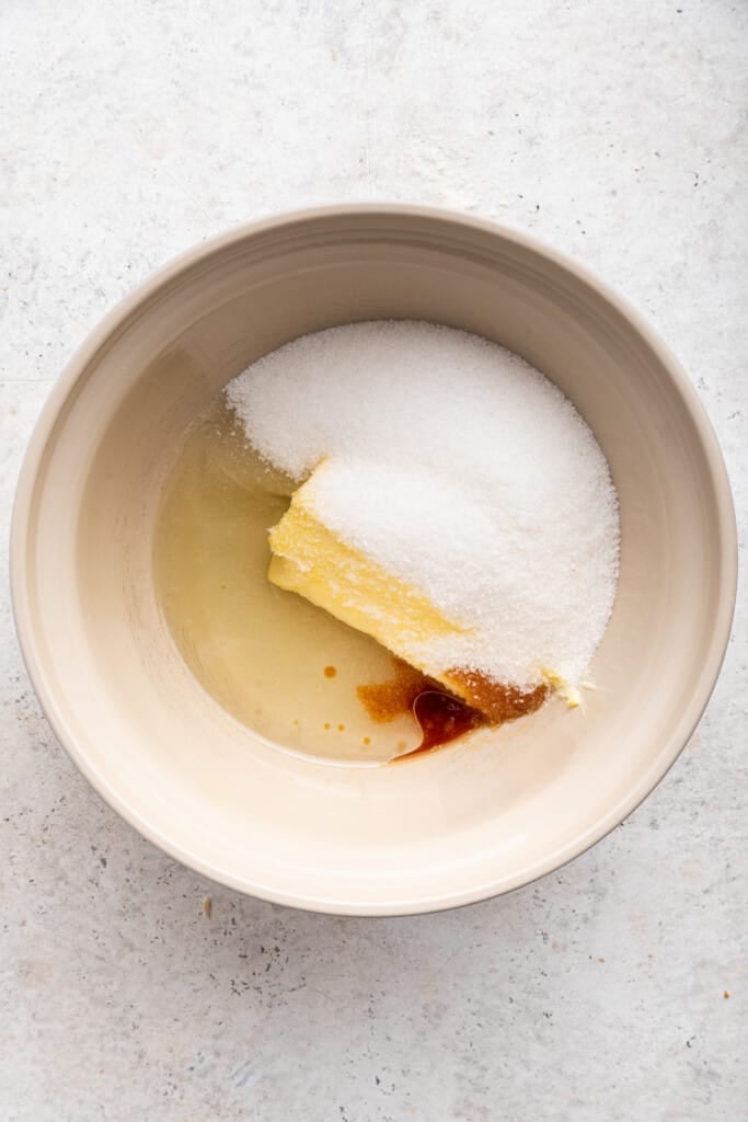 Overhead view of vanilla, butter, oil, and sugar in mixing bowl