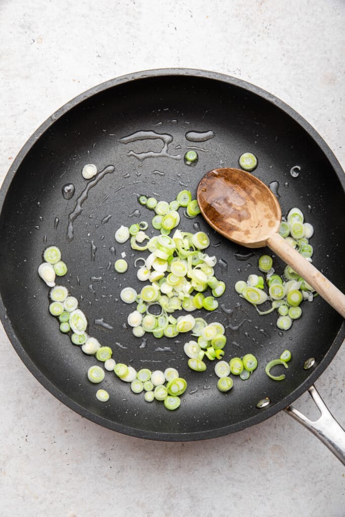 Overhead view of green onion in skillet