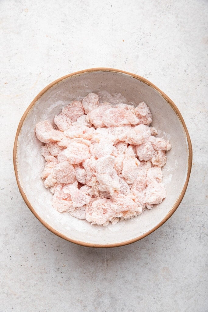 Chicken coated in cornstarch in bowl