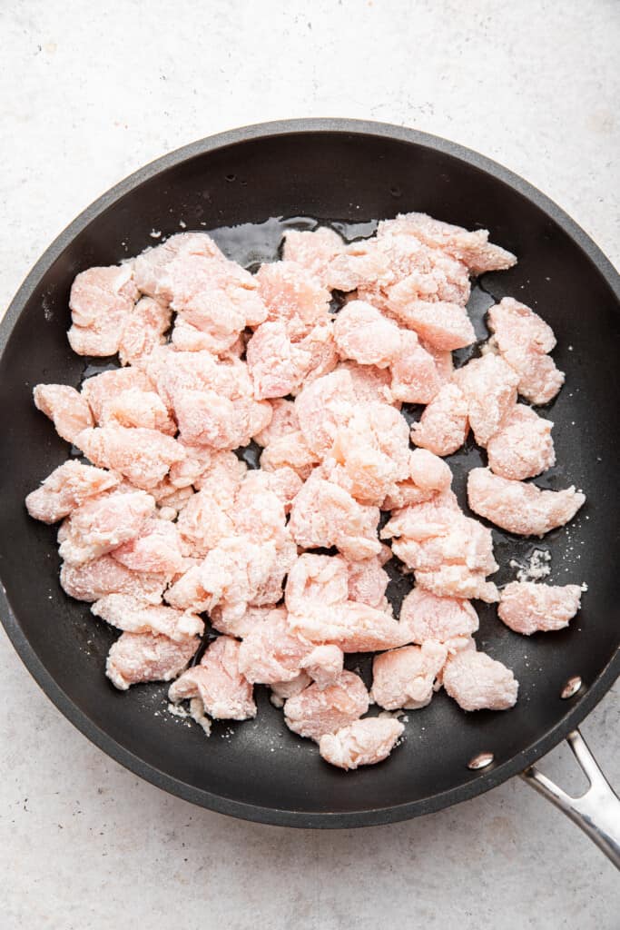 Overhead view of raw chicken in skillet