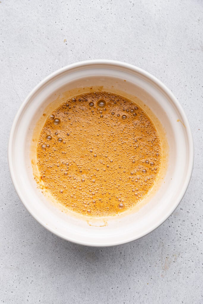 Overhead view of wet ingredients for carrot bread in mixing bowl