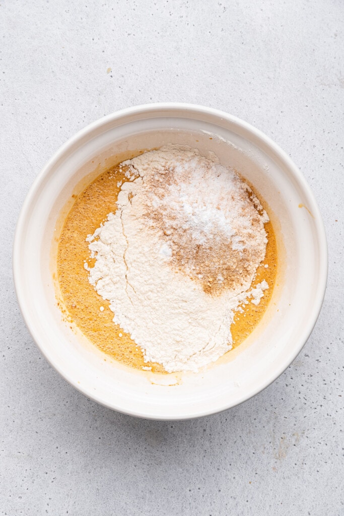 Overhead view of dry ingredients added to bowl of wet ingredients