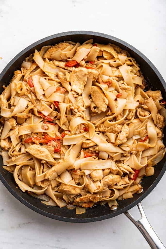 Overhead view of chicken chow fun in skillet