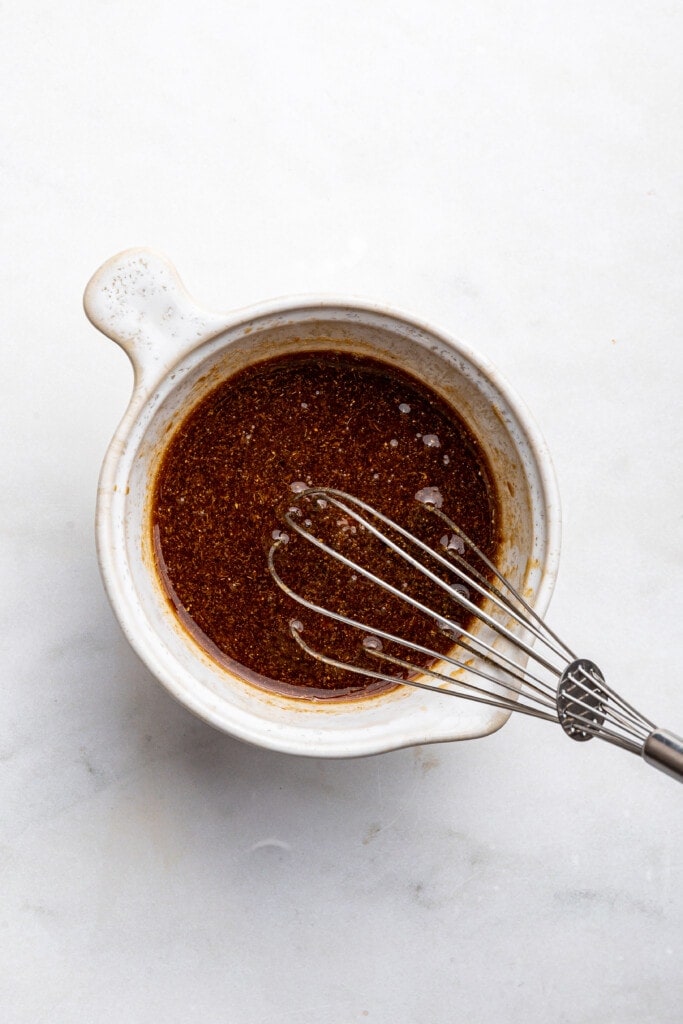 Overhead view of chow fun sauce in bowl with whisk