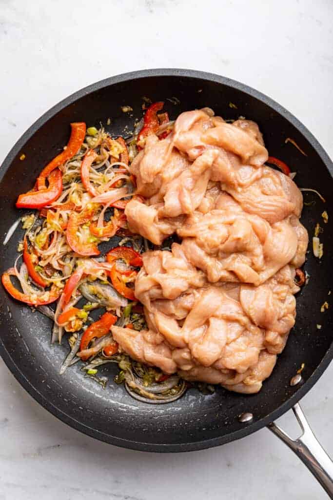 Chicken added to skillet of stir fried vegetables