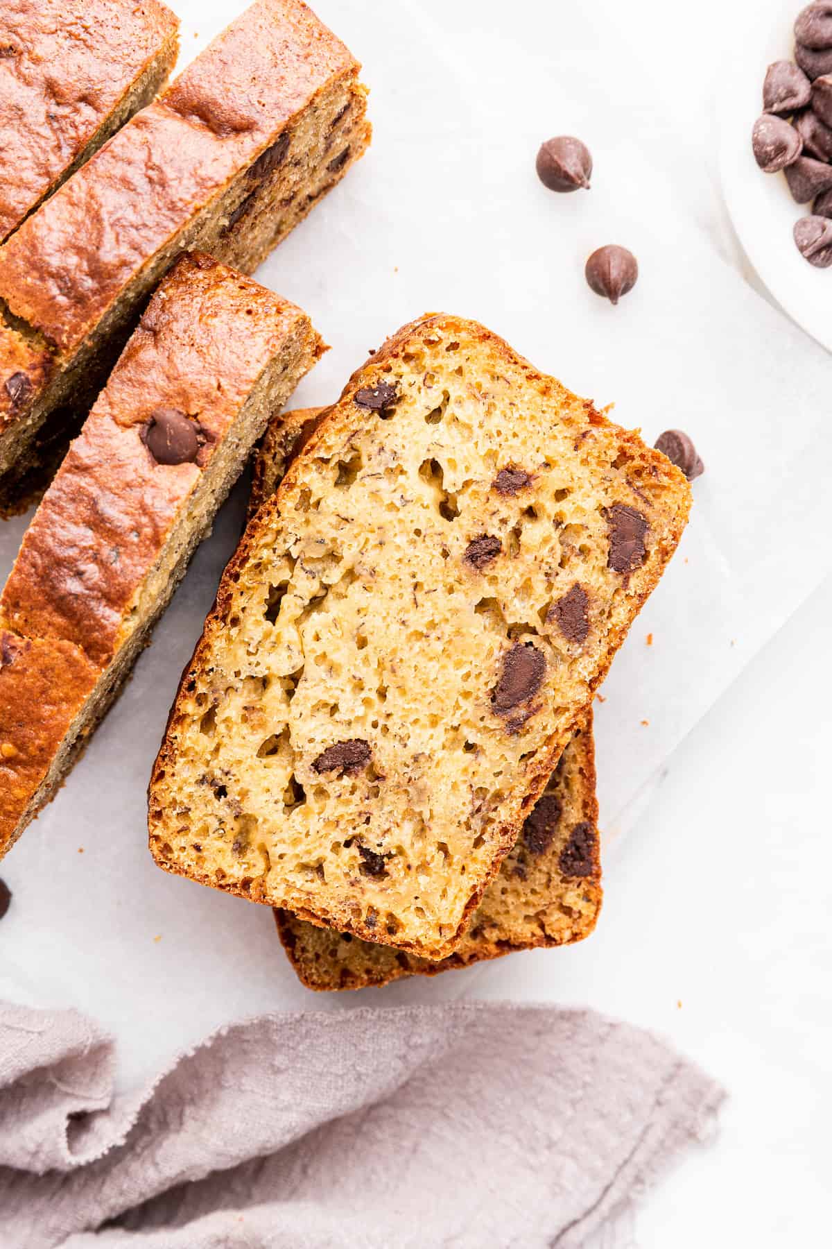 Two stacked slices of protein banana bread next to standing slices
