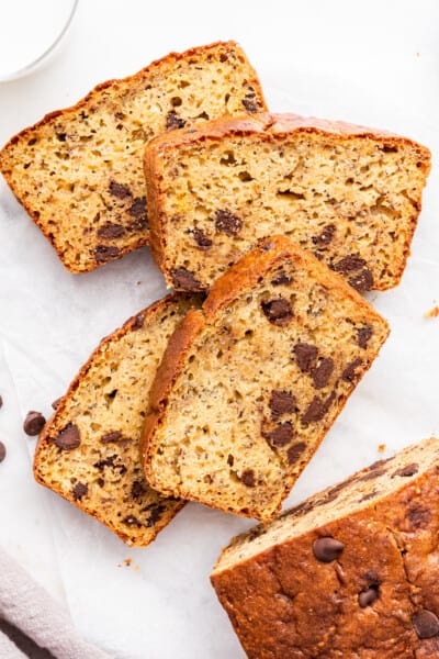 Overhead view of protein 4 banana bread slices laying on countertop next to remaining loaf