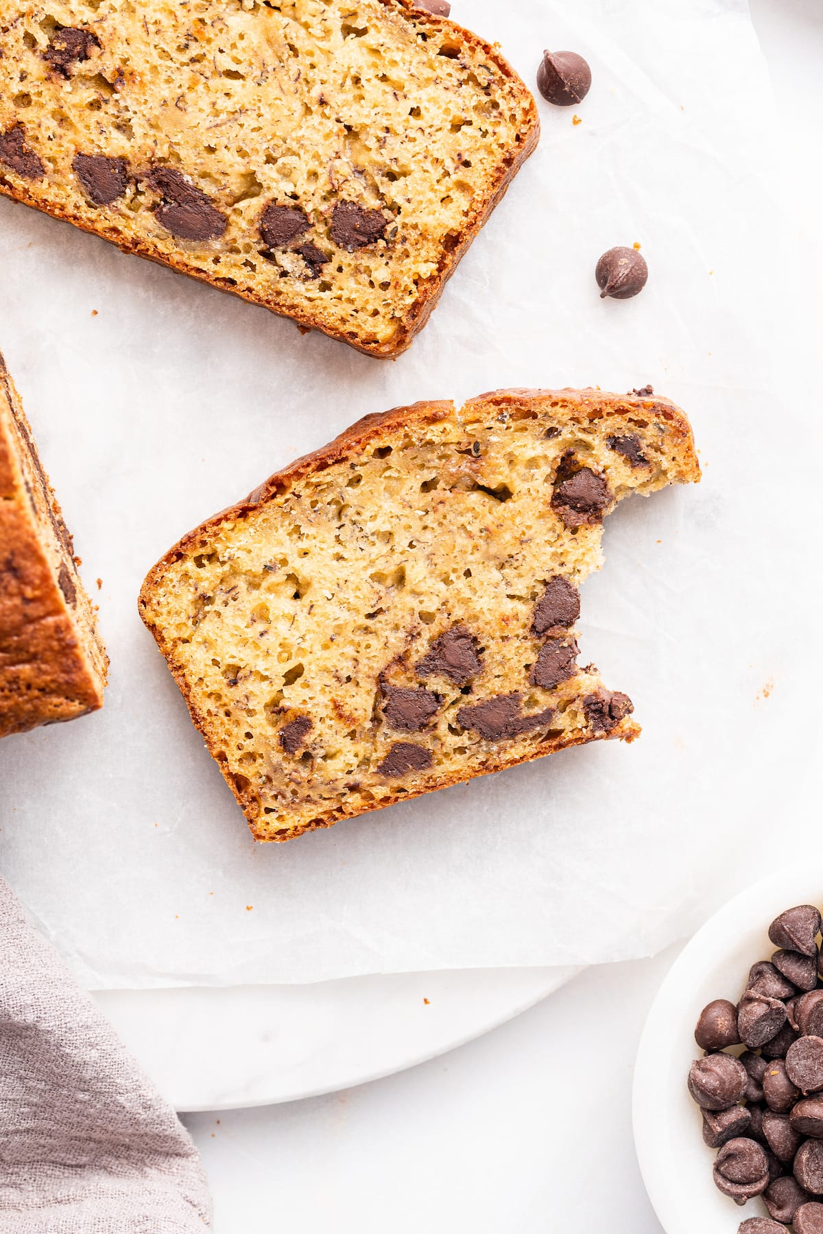Overhead view of two slices of protein banana bread, with bite taken out of one piece