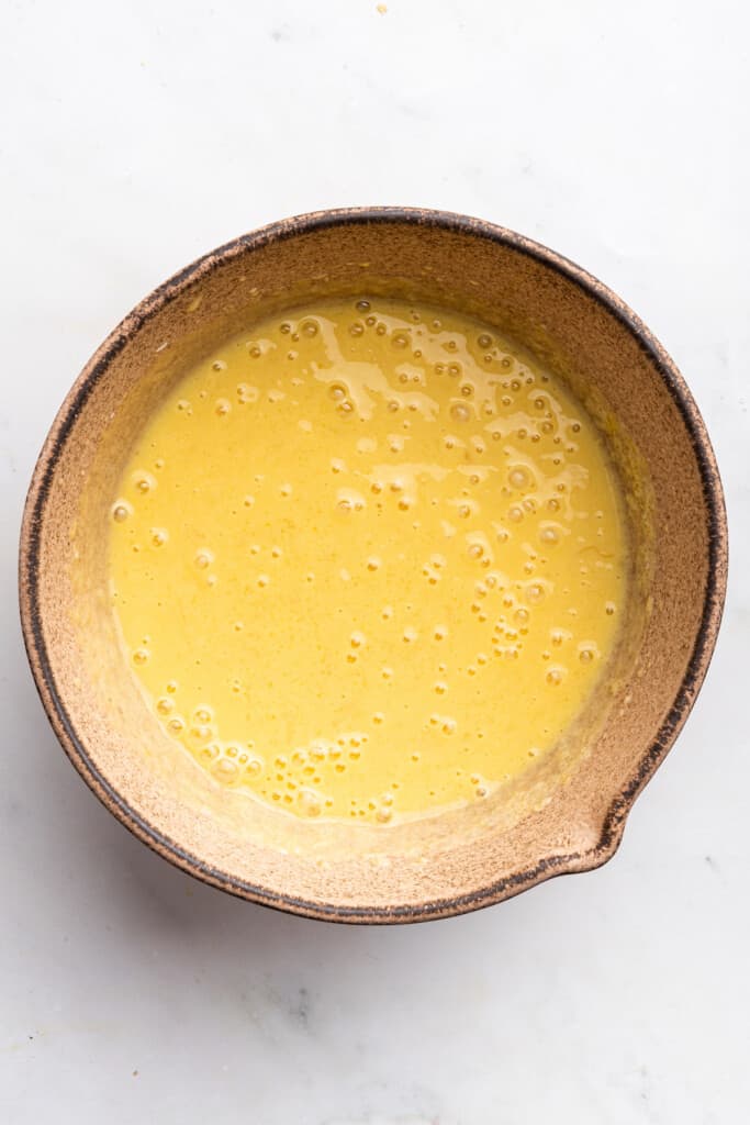 Overhead view of wet ingredients for banana bread in bowl