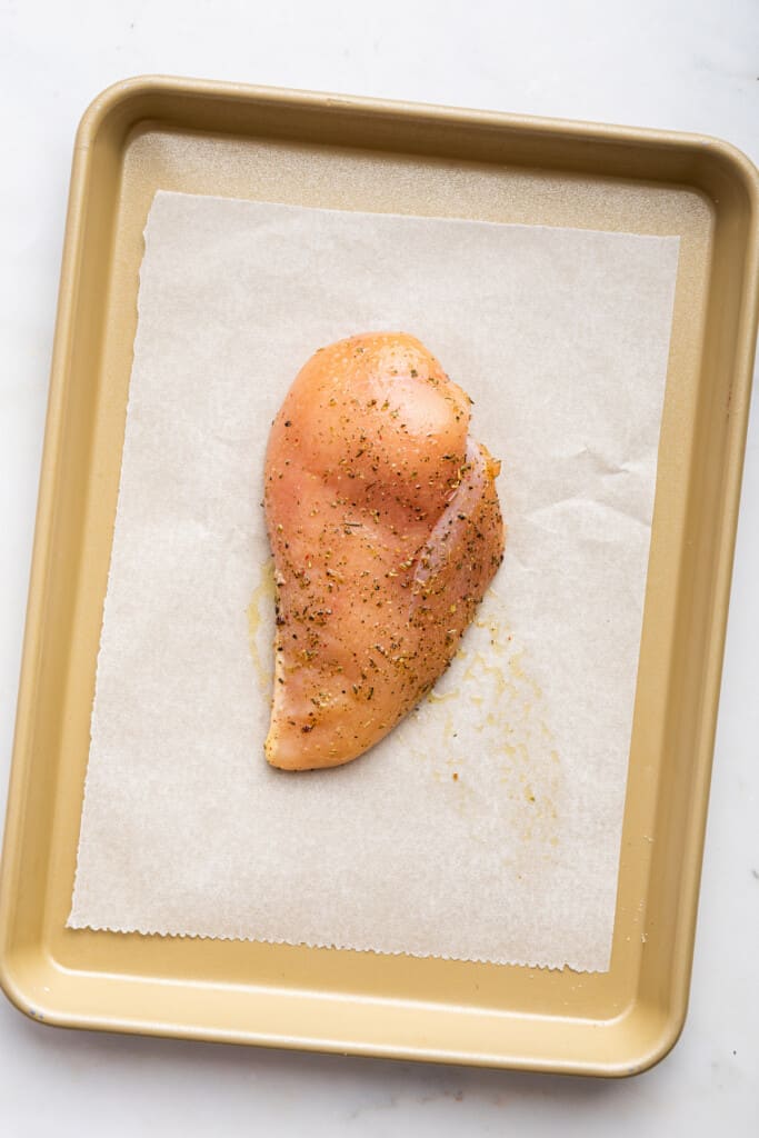 Seasoned chicken on sheet pan before baking