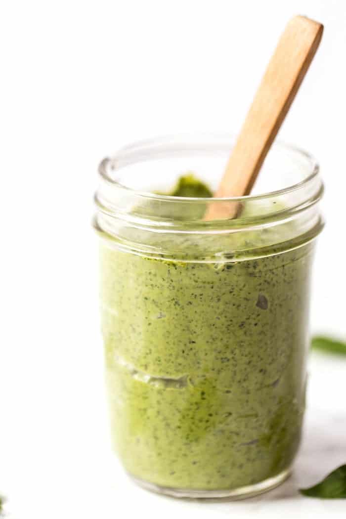 Creamy pesto in jar with spoon