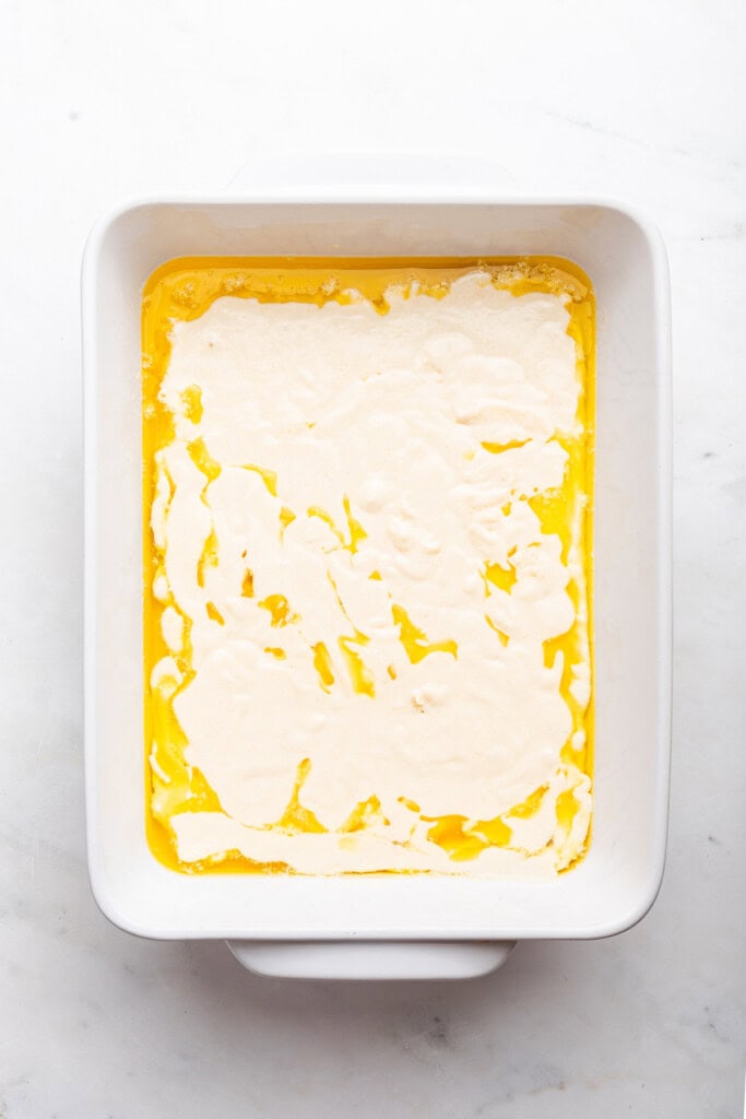 Overhead view of batter and butter in baking dish for cobbler