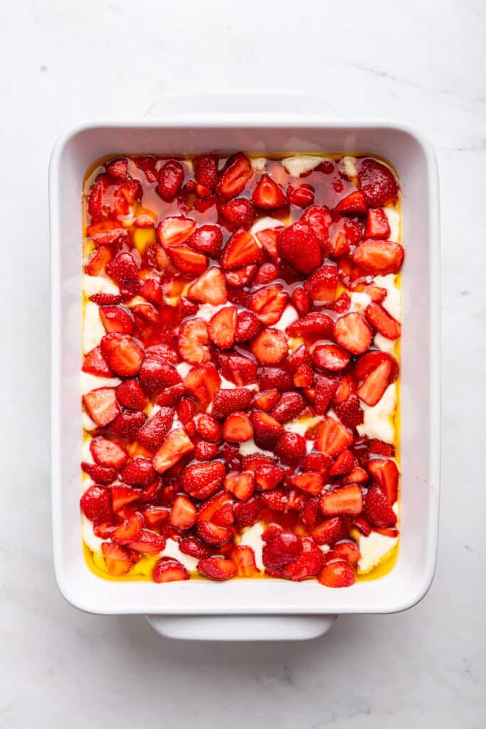 Overhead view of strawberry cobbler in baking dish before baking