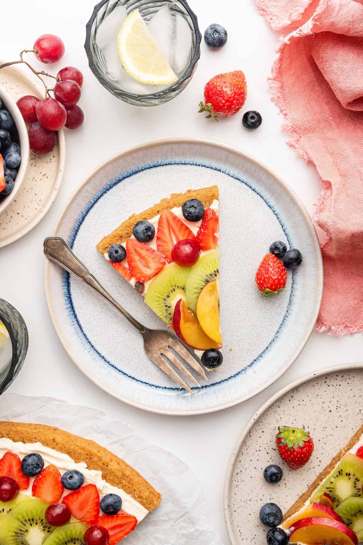 Overhead view of fruit pizza slice on plate with fork