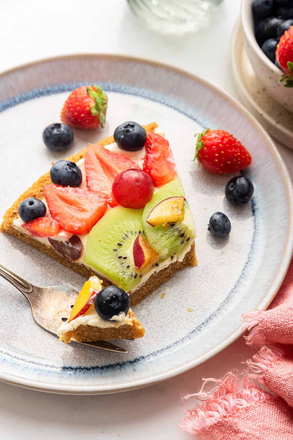 Fruit pizza on plate with tip of pizza on fork