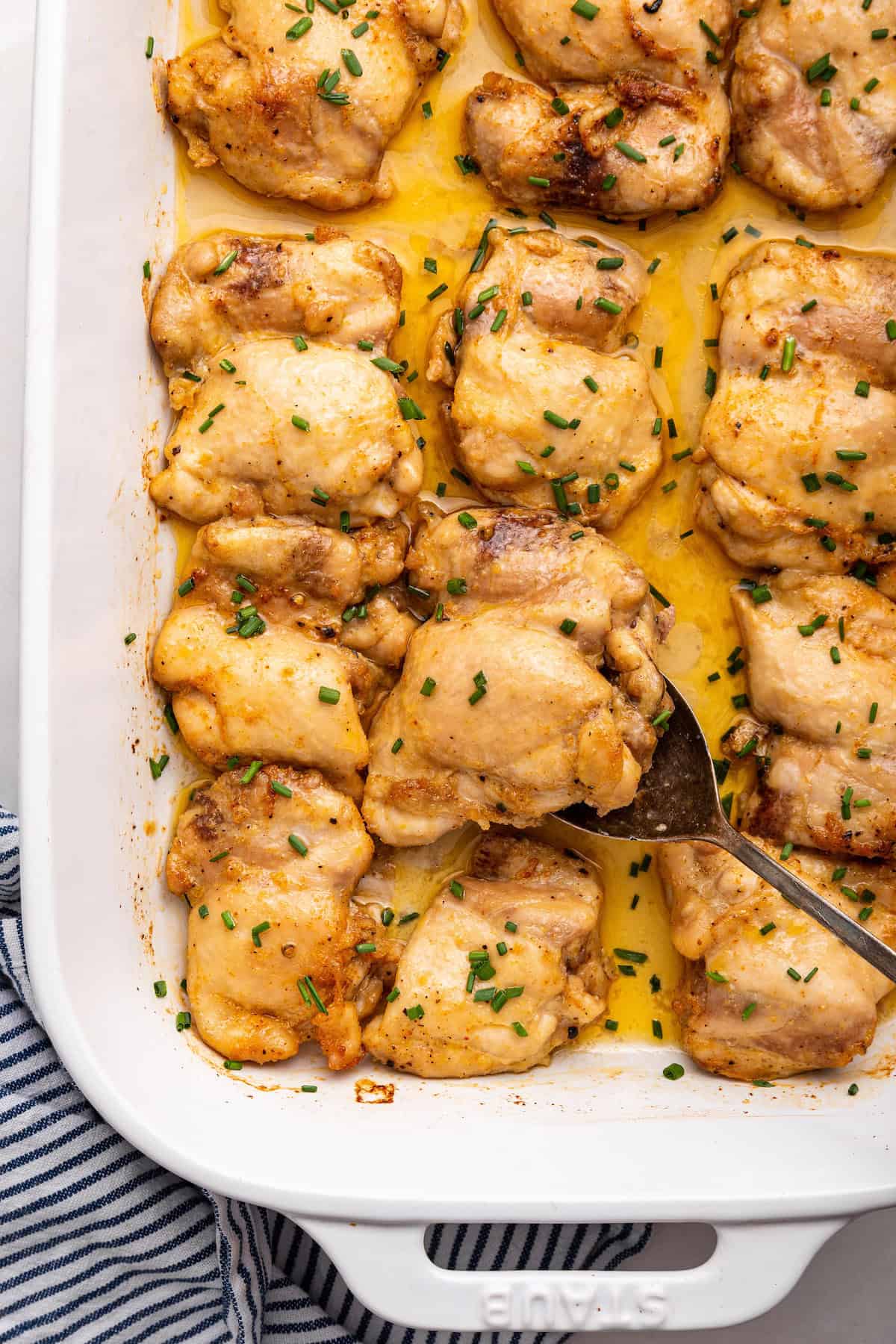 This baked boneless chicken thighs recipe is an easy weeknight meal that requires minimal prep but delivers maximum flavor. Juicy and tender! Baking dish with baked boneless chicken thighs