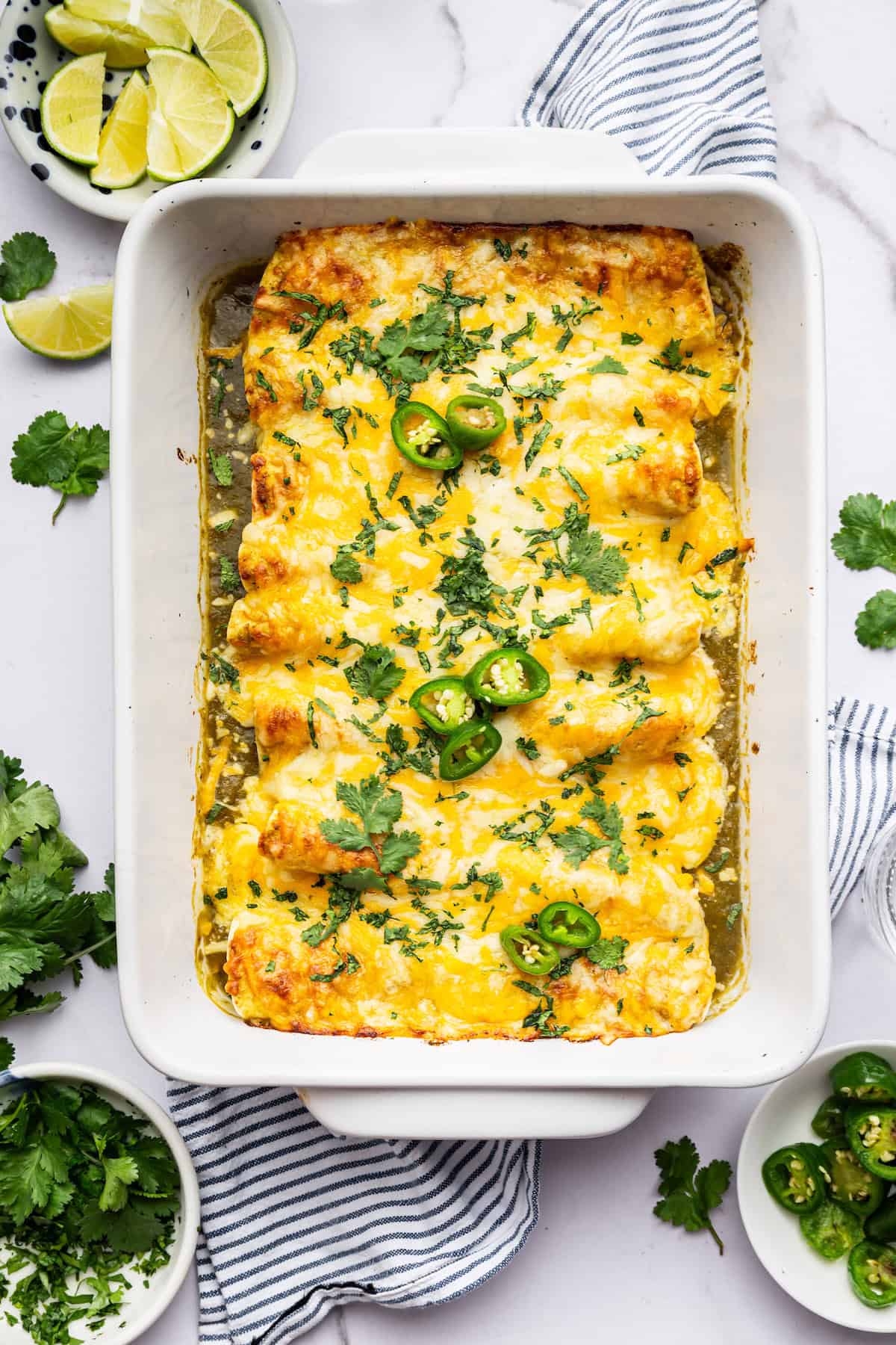 Overhead view of green chicken enchiladas in pan