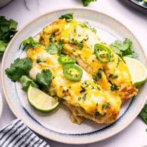 Two green chicken enchiladas on plate