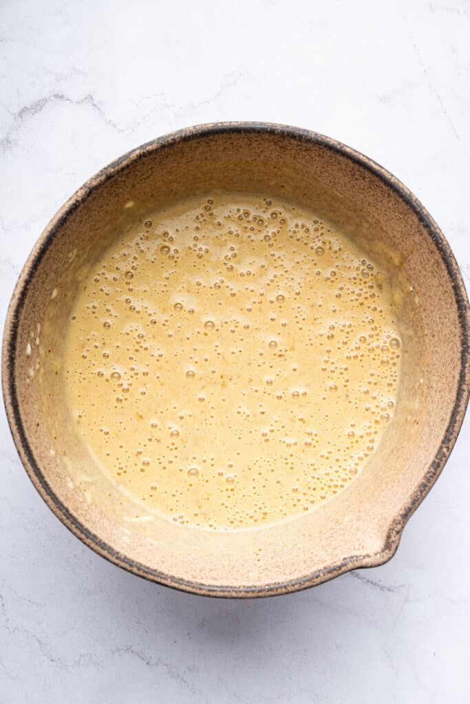 Overhead view of wet ingredients for muffins mixed in bowl