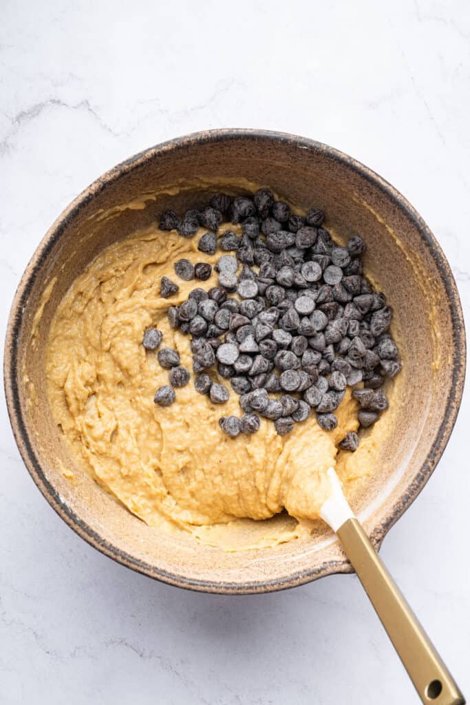 Overhead view of chocolate chips added to muffin batter