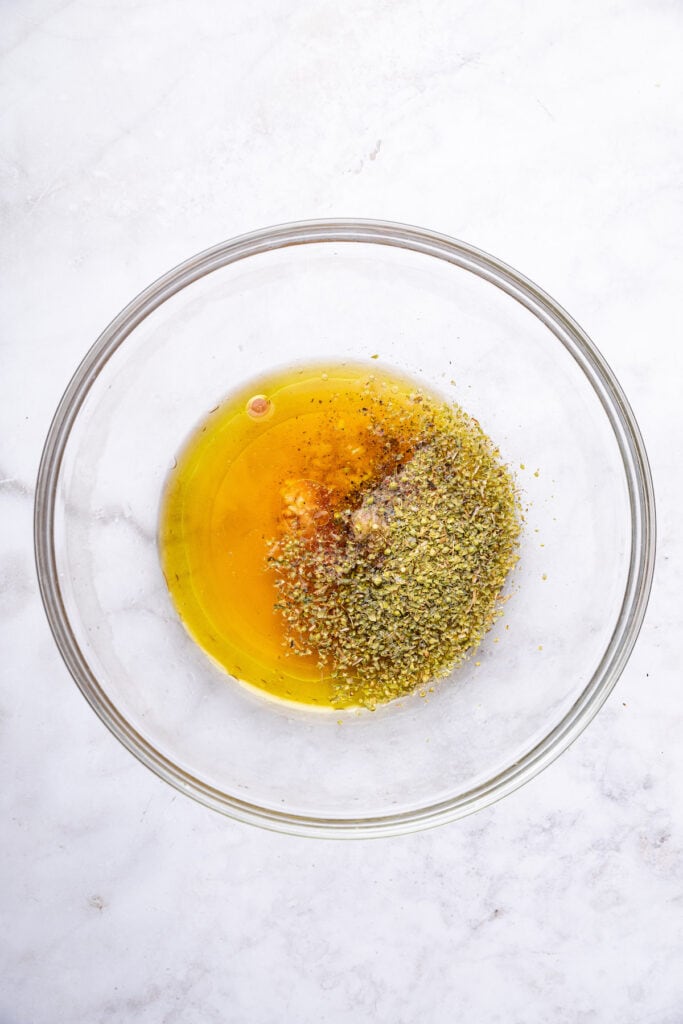 Overhead view of marinade ingredients in glass bowl before mixing