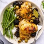 Overhead view of chicken marbella on plate with rice and green beans