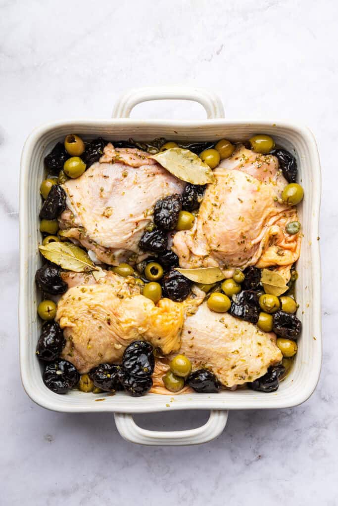 Overhead view of chicken marbella in baking dish before baking