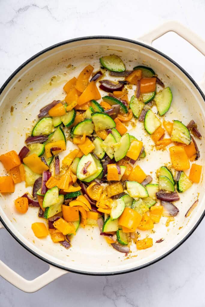 Zucchini, red onion, and yellow pepper cooking in skillet