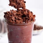 Spoonful of edible brownie batter held over jar