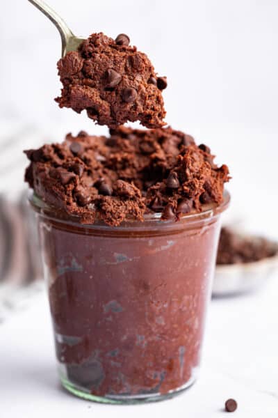 Spoonful of edible brownie batter held over jar