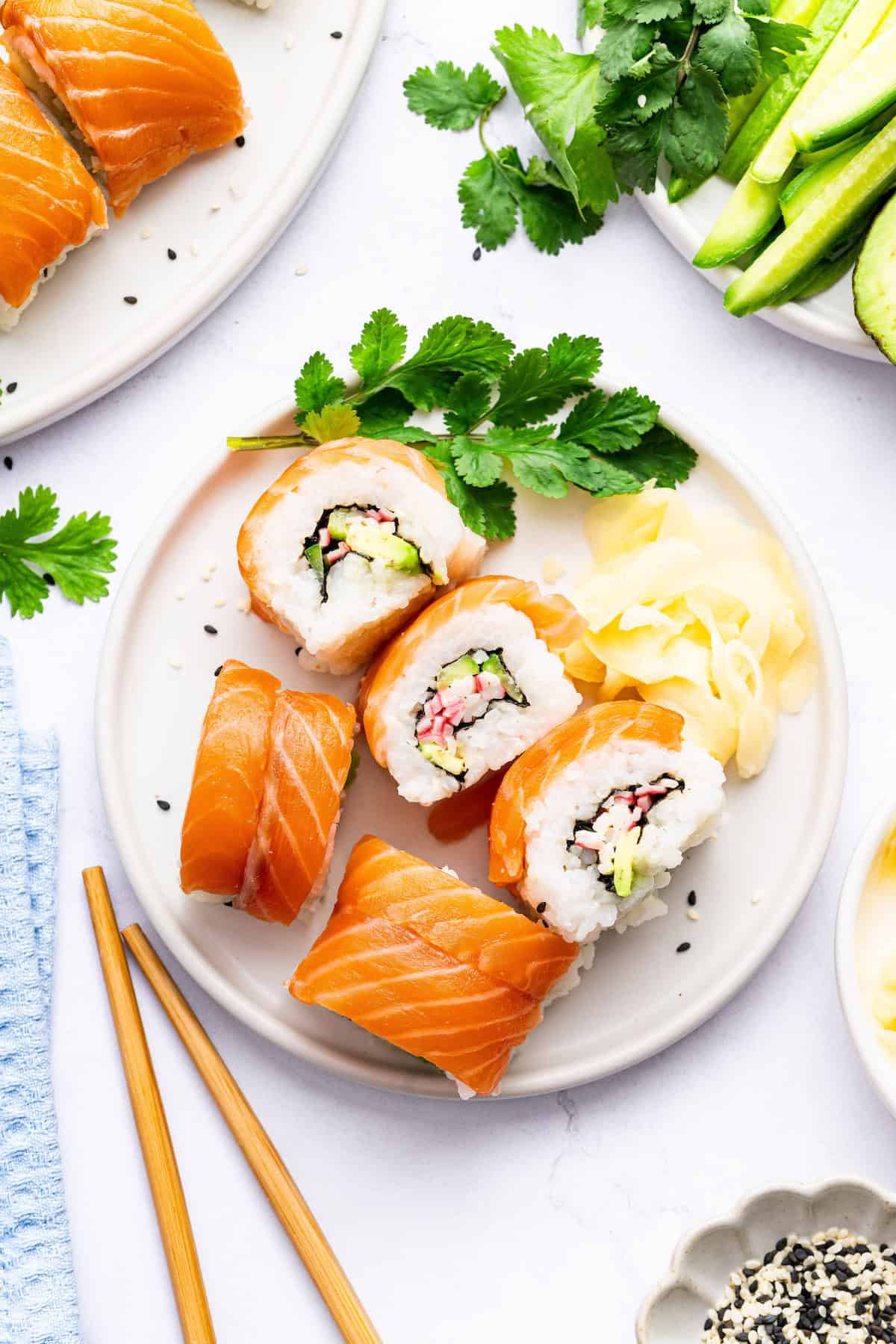 With its combination of raw salmon, soft crab, crunchy cucumber, and creamy avocado, this homemade Alaska roll recipe is irresistible! Overhead view of Alaska roll on plate with pickled ginger