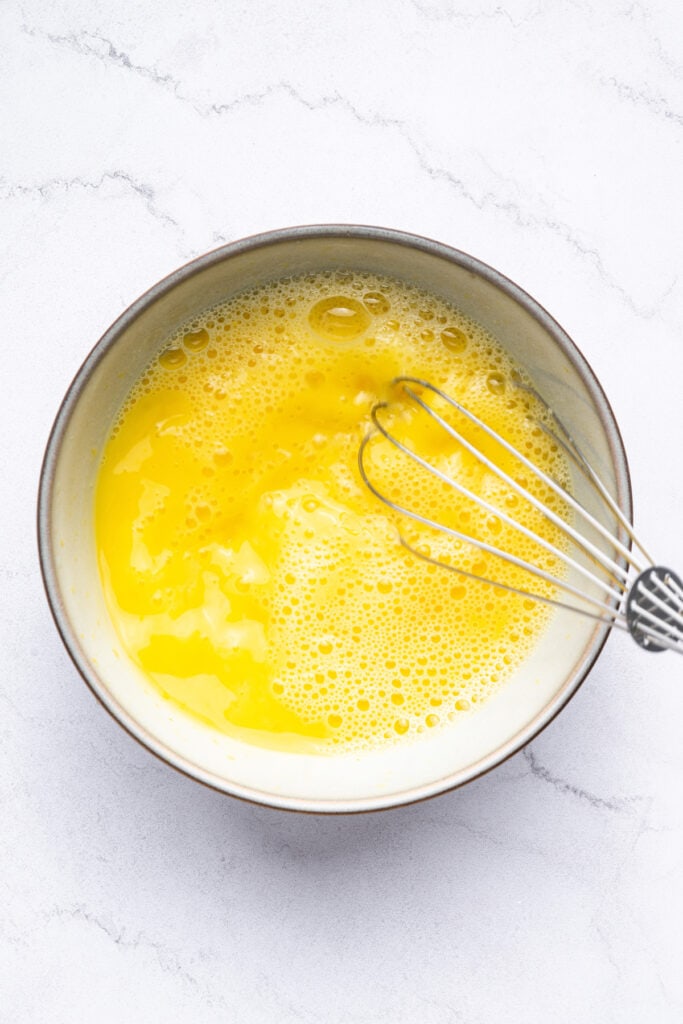 Whisking egg and lemon juice in bowl