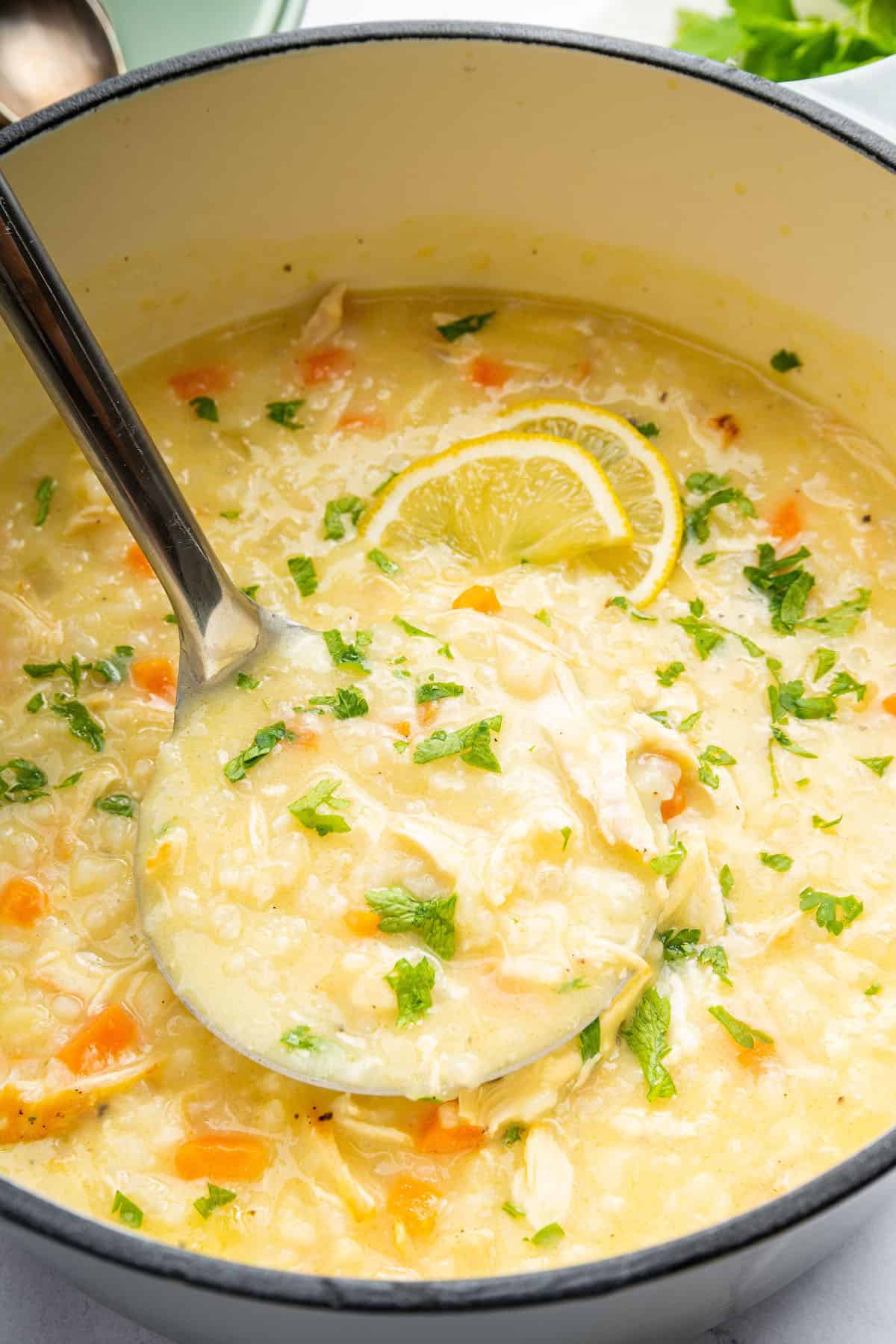 Ladleful of avgolemono soup in pot