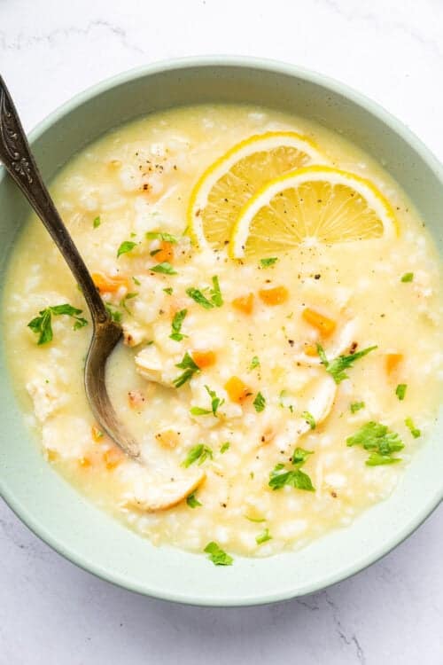 Bowl of avgolemono soup with fresh lemon slices
