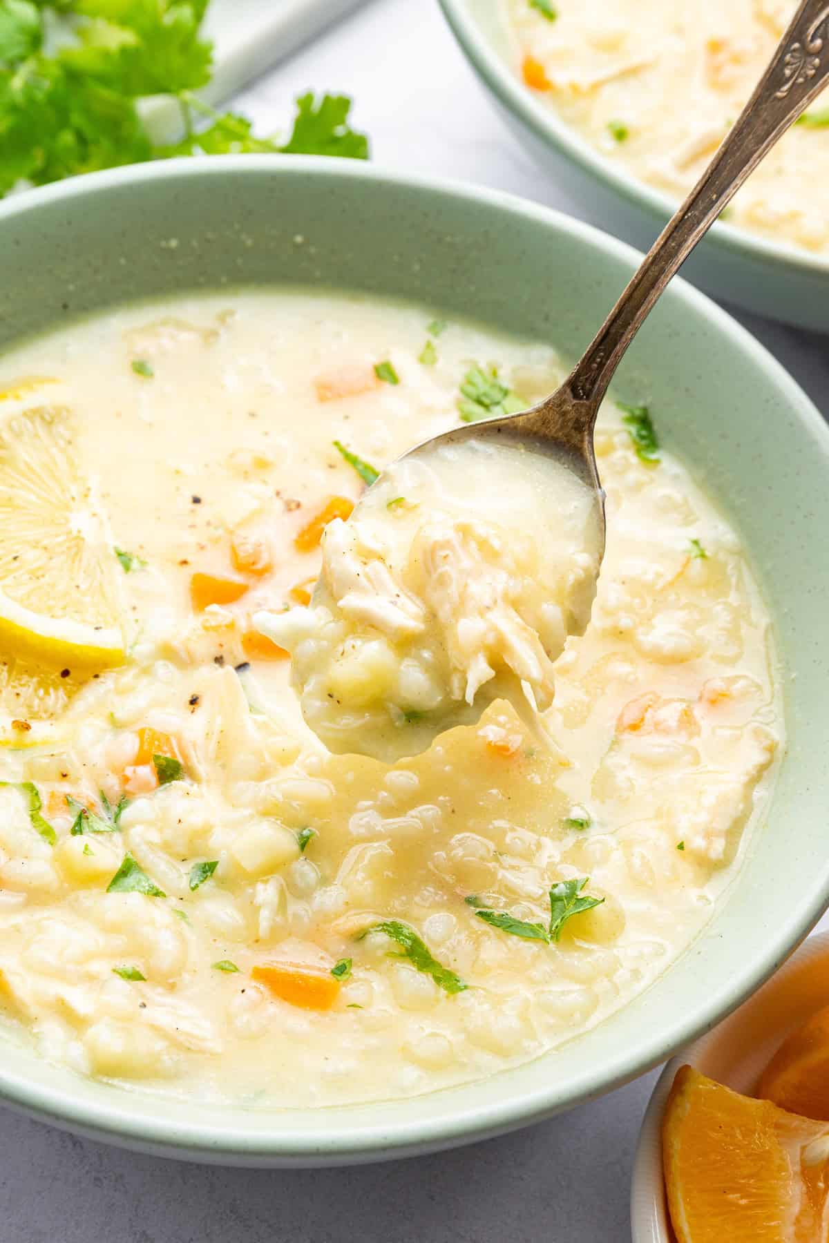 Spoonful of avgolemono soup held over bowl