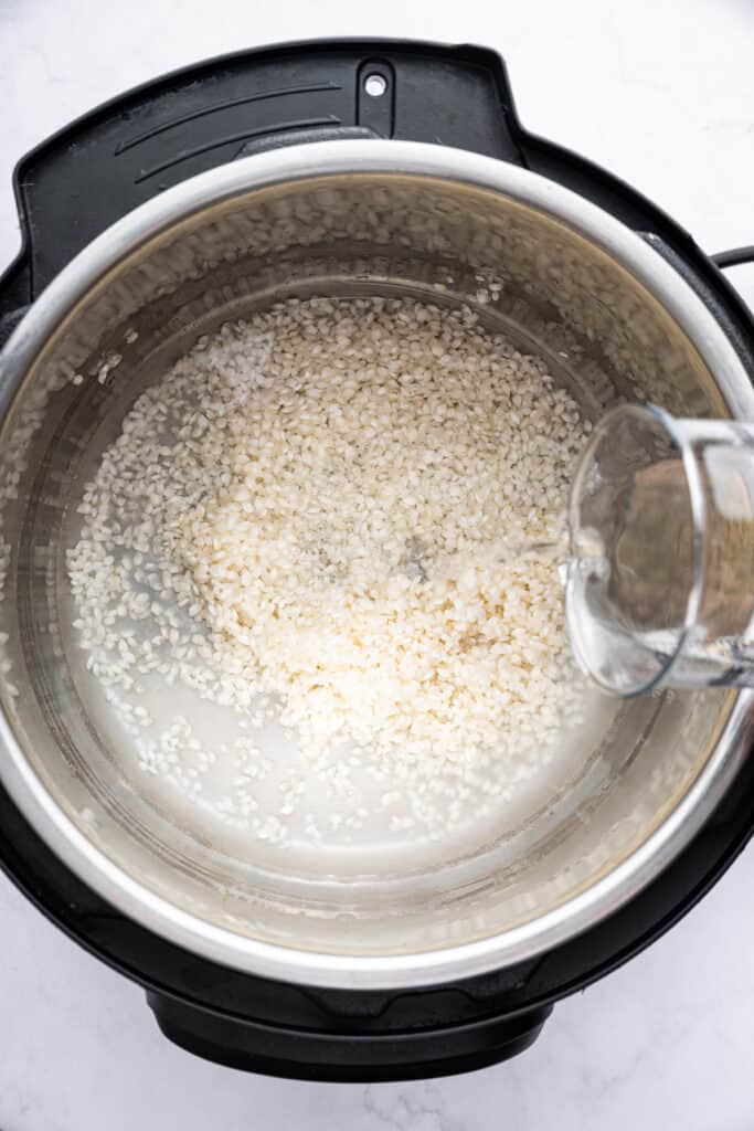 Pouring water into Instant Pot with rice