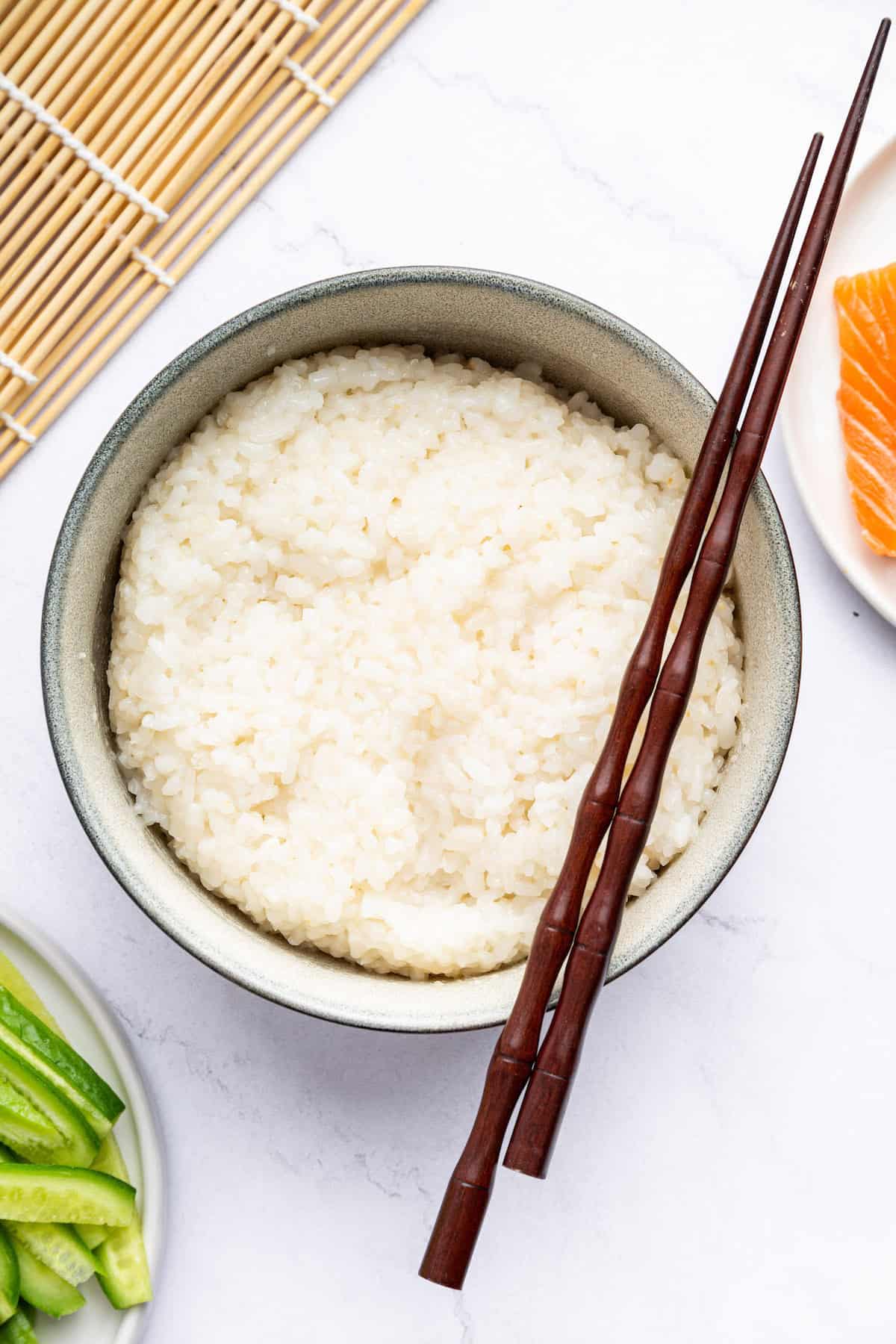 With a delicate flavor and easy prep, this Instant Pot sushi rice is perfect for making onigiri, rice bowls and all your favorite sushi rolls! Overhead view of Instant Pot sushi rice in bowl with chopsticks