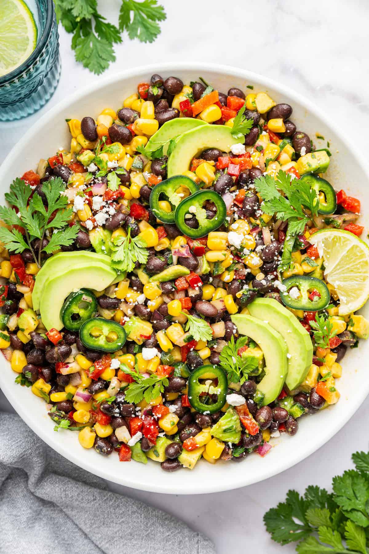 Black bean and corn salad is made with bell pepper, red onion, avocado, and cilantro, with a zippy lime vinaigrette to bring it all together! Black bean and corn salad in large serving bowl