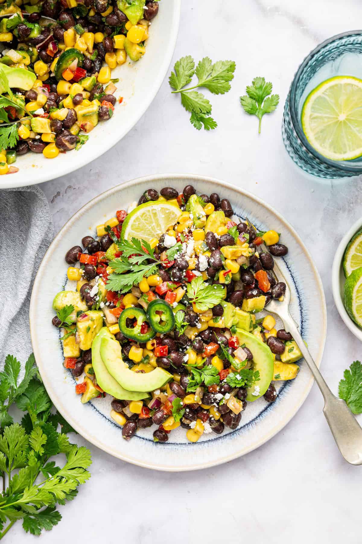 Black bean and corn salad on plate and in serving bowl
