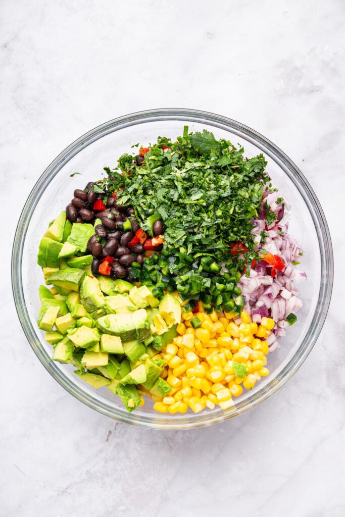 Overhead view of ingredients for black bean and corn salad in mixing bowl